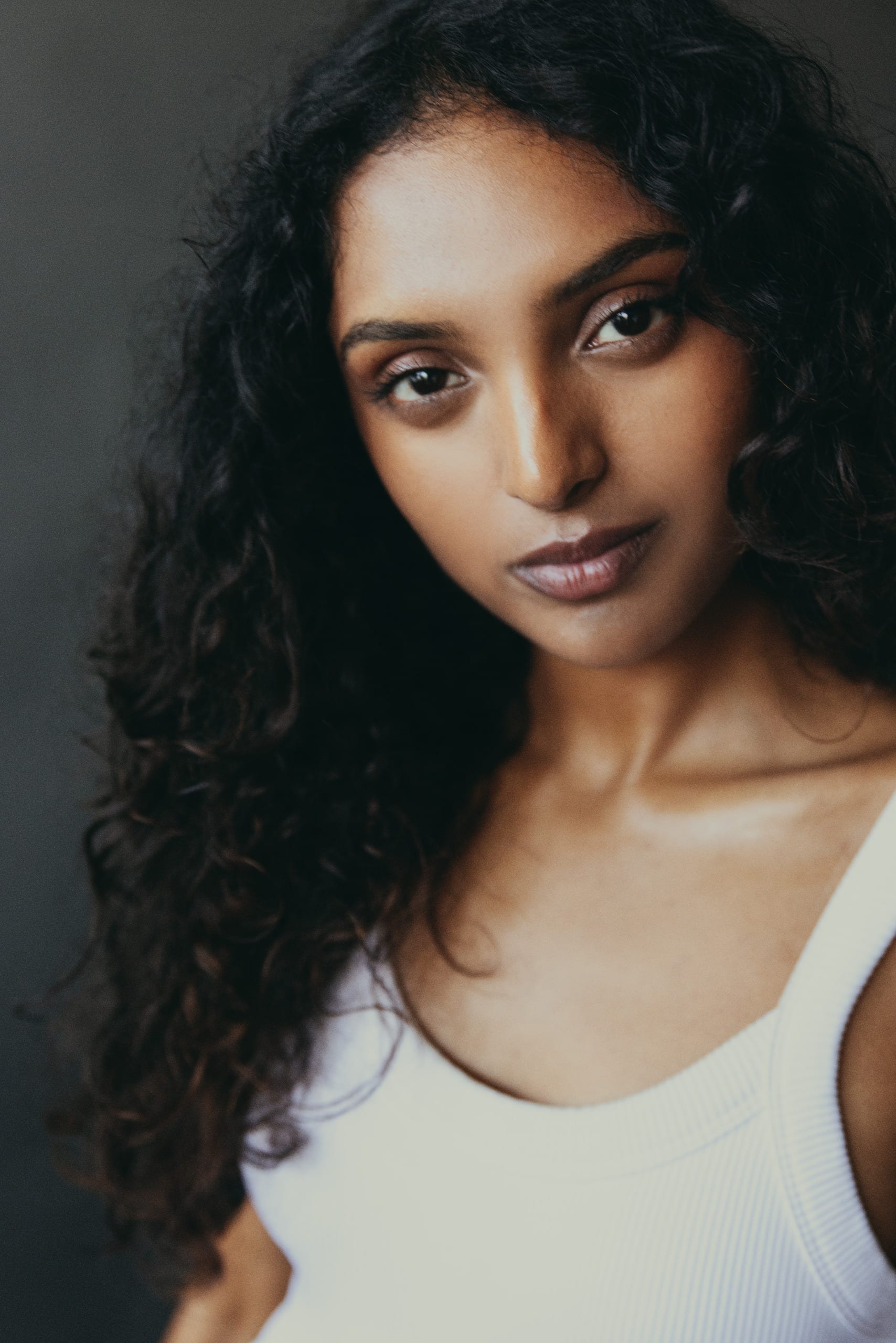 Digital — mid-shot portrait in a white tank, grey studio wall